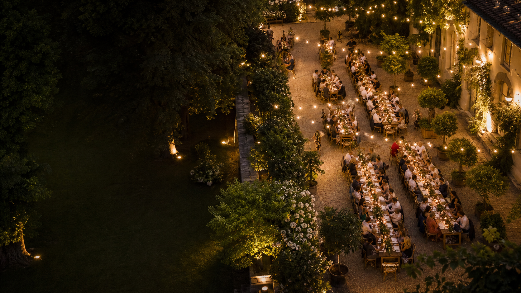 Outdoor-Event mit gedeckten Tischen und warmen Lichtern aus erhöhter Perspektive